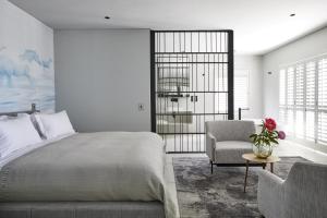 a bedroom with a bed and a chair at Kianga in Gordonʼs Bay