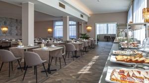 アーバノ・テルメにあるホテル　ブリストルブジャのテーブルと椅子、料理を提供するレストラン