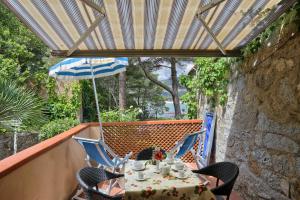 a table and chairs on a balcony with an umbrella at Residence Vacanza Mare in Campo nell'Elba