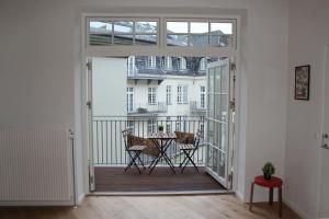 una puerta abierta a un balcón con mesa y sillas en Luxury in the Heart of Copenhagen Near Harbour Baths, en Copenhague