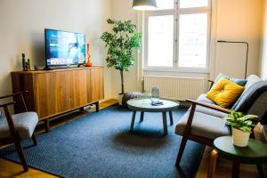 a living room with a tv and a couch and a table at Luxury in the Heart of Copenhagen Near Harbour Baths in Copenhagen