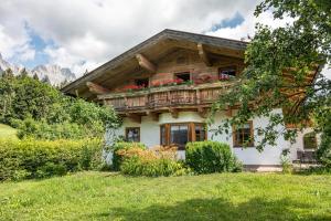 a house in the mountains with flowers on the balcony at Chalet Glücklich sein... in Ellmau