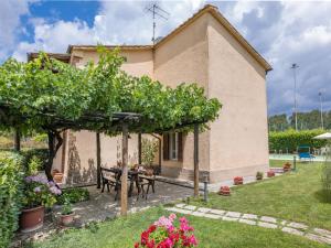 a house with a table and a bunch of grapes at La Pergola in Monticiano