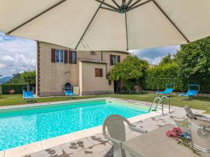 a swimming pool with chairs and an umbrella at La Pergola in Monticiano