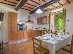 a dining room with a table and a kitchen at La Pergola in Monticiano