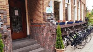 アムステルダムにあるデ ベッドステー ブティック カプセルズの煉瓦造りの建物の隣に停められた自転車の一団
