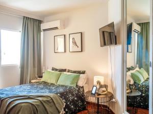 トレモリノスにあるAmazing Studio Torremolinosのベッドルーム1室(青いシーツと緑の枕が備わるベッド1台付)
