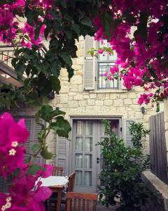 a house with pink flowers in front of it at Çona Butik Otel in Alacati