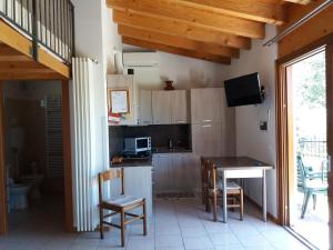 una cocina con mesa, sillas, mesa y mesa en B&B Camister, en Toscolano Maderno