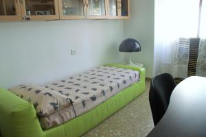 uma cama verde num quarto com um candeeiro em LOLA em Granada