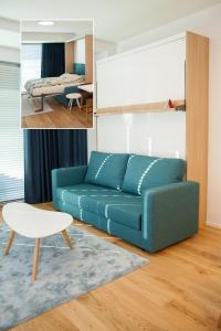 ein Wohnzimmer mit einem blauen Sofa und ein Schlafzimmer in der Unterkunft Riverside Apartment in Pärnu