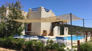 a villa with a swimming pool and a group of chairs at L'Olla in Cala Ratjada