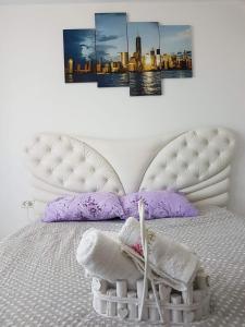 a bedroom with a white bed with purple pillows at Apartament de lux Mamaia Nord in Mamaia