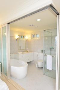 a white bathroom with a tub and a sink at Ming Ging Farm in Renai