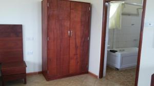 ein Badezimmer mit einem Holzschrank und einem WC in der Unterkunft Hotel Dot Com Entebbe in Entebbe