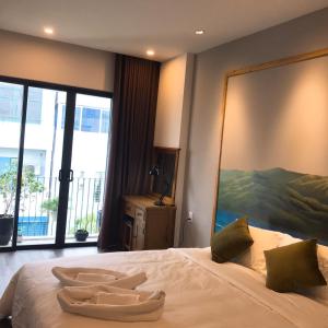 een slaapkamer met een groot bed en een groot schilderij aan de muur bij Banana Flower Homestay in Da Nang