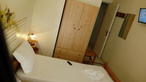 a bedroom with a bed and a wooden door at Kadmos in Loutra Edipsou