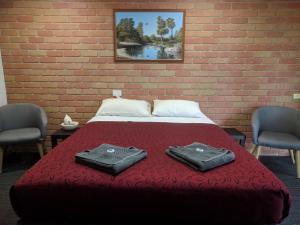 1 dormitorio con 1 cama con 2 toallas en Travellers Inn Kaniva en Kaniva