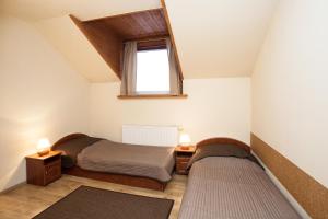 シュチルクにあるWilla Pod Magurąの小さなベッドルーム(ベッド2台、窓付)