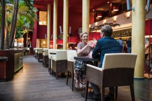 a man and woman sitting at a table in a restaurant at Hotel Therme Meran - Terme Merano in Merano