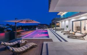 une piscine avec des chaises longues et un parasol dans l'établissement Villa Emelie, à Medulin