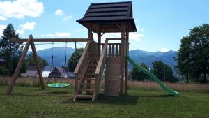 une aire de jeux en bois avec une tour et une échelle dans l'établissement Domek Góralski na Gubałówce, à Zakopane