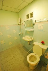 a bathroom with a toilet and a sink at Boathouse Resort Suanphung in Suan Phung