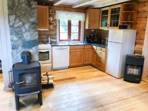 a kitchen with a wood stove and a refrigerator at Tjonnas Farm Stay in Sauland +19 photos