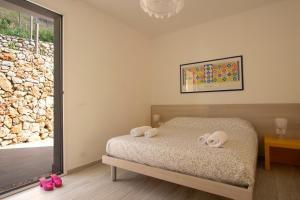 a bedroom with a bed with two towels on it at Villa Vitruvio - Giardino degli Allori Scopello in Castellammare del Golfo +27 photos