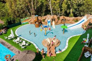 a group of people in a pool at a water park at Apartaments Els Llorers in Lloret de Mar