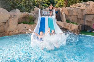 two girls on a water slide at a water park at Apartaments Els Llorers in Lloret de Mar