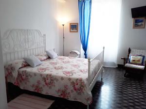 um quarto com uma cama com colcha floral em La casa di Nonna Fo em Voltaggio