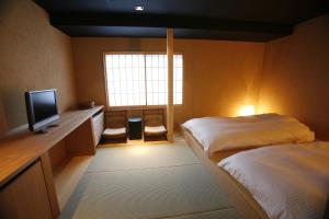 Postel nebo postele na pokoji v ubytování Masutomi Ryokan