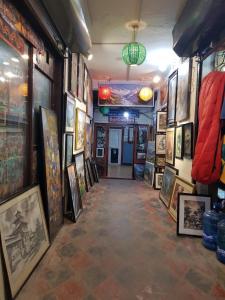 a hallway with paintings and pictures on the walls at Hotel Down Town in Kathmandu