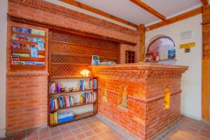 a brick wall with a shelf of books at Welcome Heritage Inn in Bhaktapur