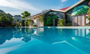 a swimming pool in front of a house at Son Doong Bungalow in Phong Nha