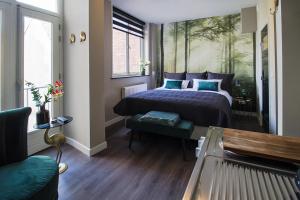 a bedroom with a bed with a painting on the wall at Citystays Deventer in Deventer