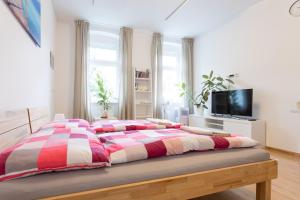 sypialnia z łóżkiem z czerwonym i białym kocem w obiekcie Vienna Smile Apartment Schoenbrunn w Wiedniu