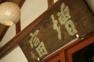 a sign on the door of a restaurant with a light at Masutomi Ryokan in Hakone