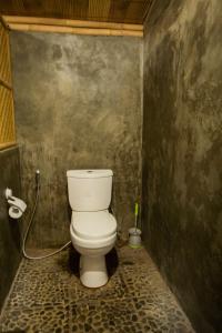 a bathroom with a white toilet in a room at Salty Shakas Bamboo Stay Canggu in Canggu