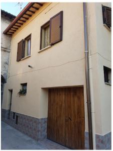 un bâtiment avec une porte de garage en bois et des fenêtres. dans l'établissement CASA HELENA, à Foligno