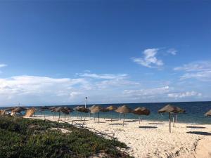 een groep parasols op een strand met de oceaan bij Dunes ressort chott Meriem in Sousse