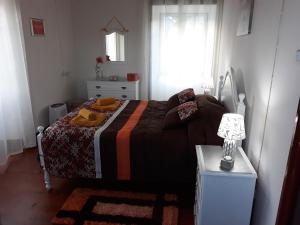 um quarto com uma cama e uma mesa com um candeeiro em Casa da Tia Marina em Lajes das Flores