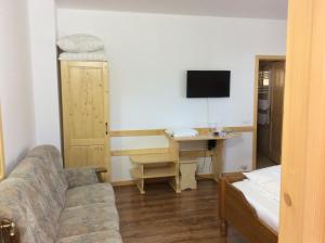 a living room with a couch and a desk with a computer at Pensiunea L`Amoro in Neagra Şarului