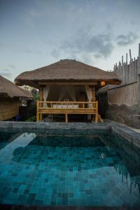 een zwembad met een tuinhuisje in de tuin bij Salty Shakas Bamboo Stay Canggu in Canggu