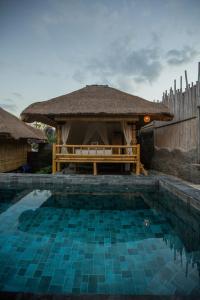 a swimming pool with a gazebo in a yard at Salty Shakas Bamboo Stay Canggu in Canggu +17 photos