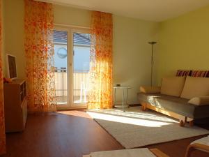 ein Wohnzimmer mit einem Sofa und einem Fenster in der Unterkunft Ferienwohnung Schnee in Bischoffingen