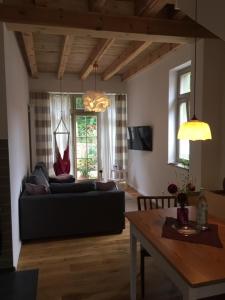 a living room with a black couch and a table at Ferienwohnung Kamp "Blick ins Grüne" in Potsdam