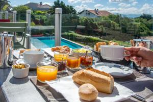 a table with a breakfast of bread and orange juice at Hotel Itsas Mendia in Bidart