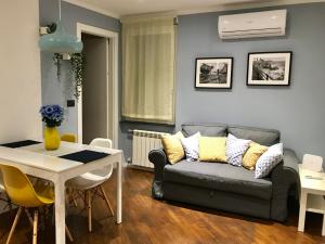 ein Wohnzimmer mit einem Sofa und einem Tisch in der Unterkunft Otello Apartment in Genua